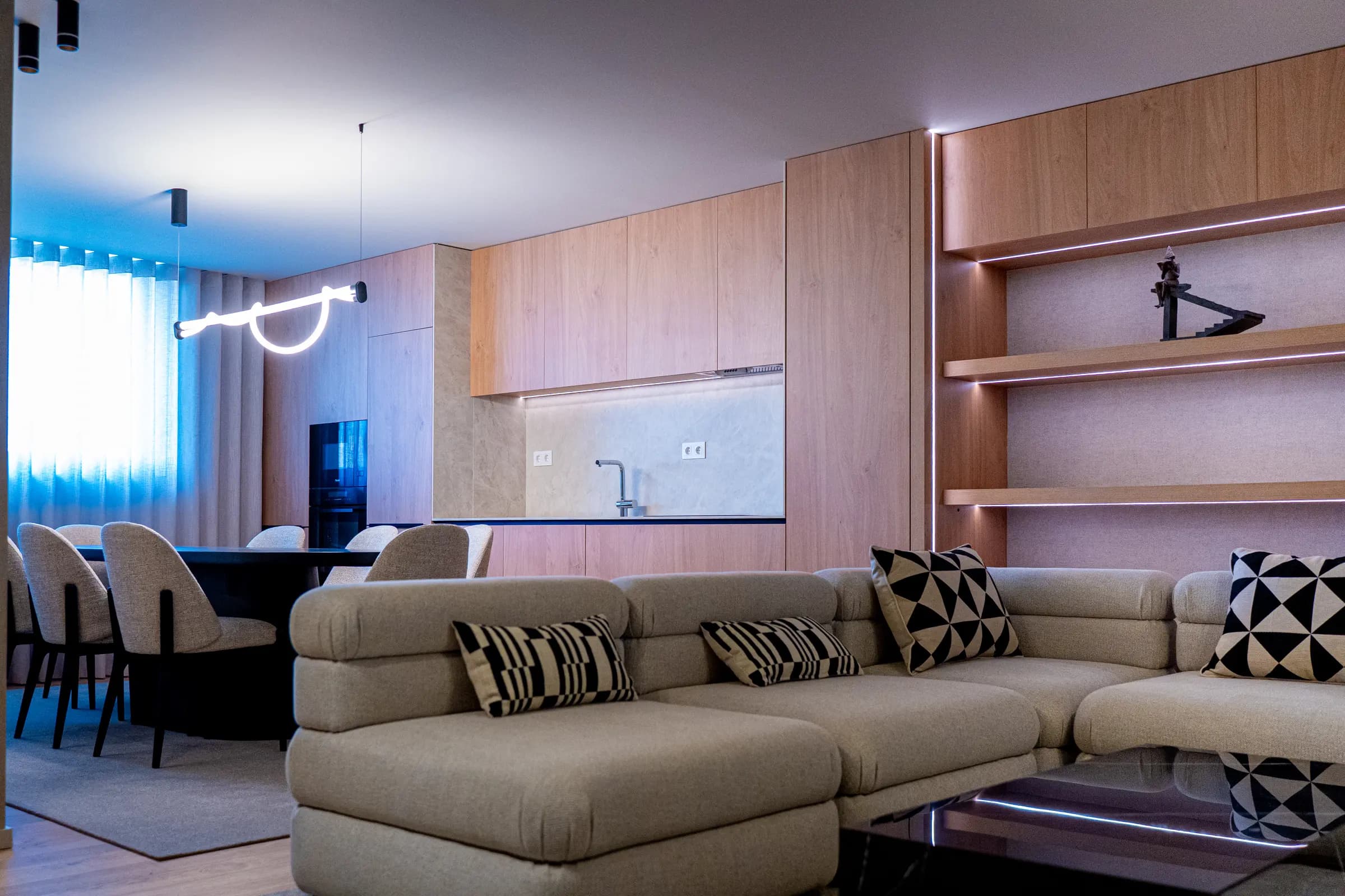 Sala e cozinha de um apartamento Metro Village, com mobiliário em tons claros